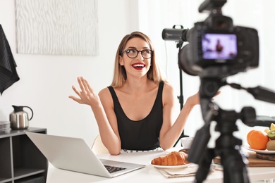 Photo of Food blogger recording video on camera at home