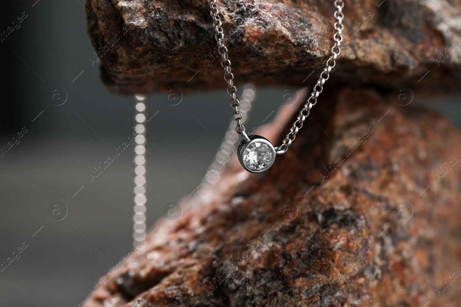 Photo of Beautiful necklace on stone stand. Luxury jewelry