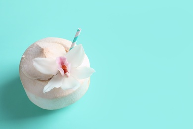 Fresh coconut drink in nut on color background