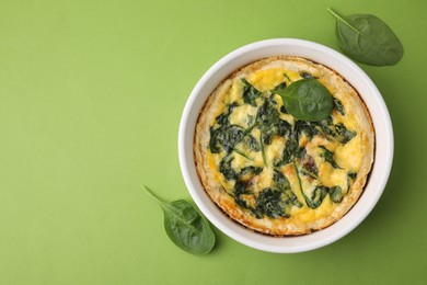 Photo of Delicious pie with spinach on green background, top view. Space for text