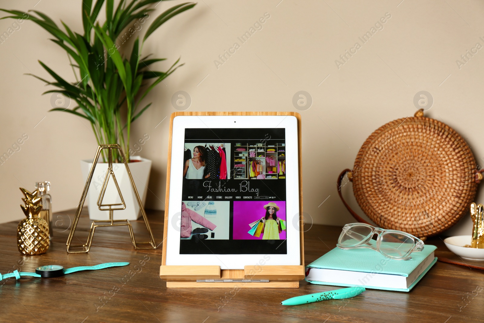 Photo of Stylish workplace with modern tablet on table near color wall. Fashion blogger