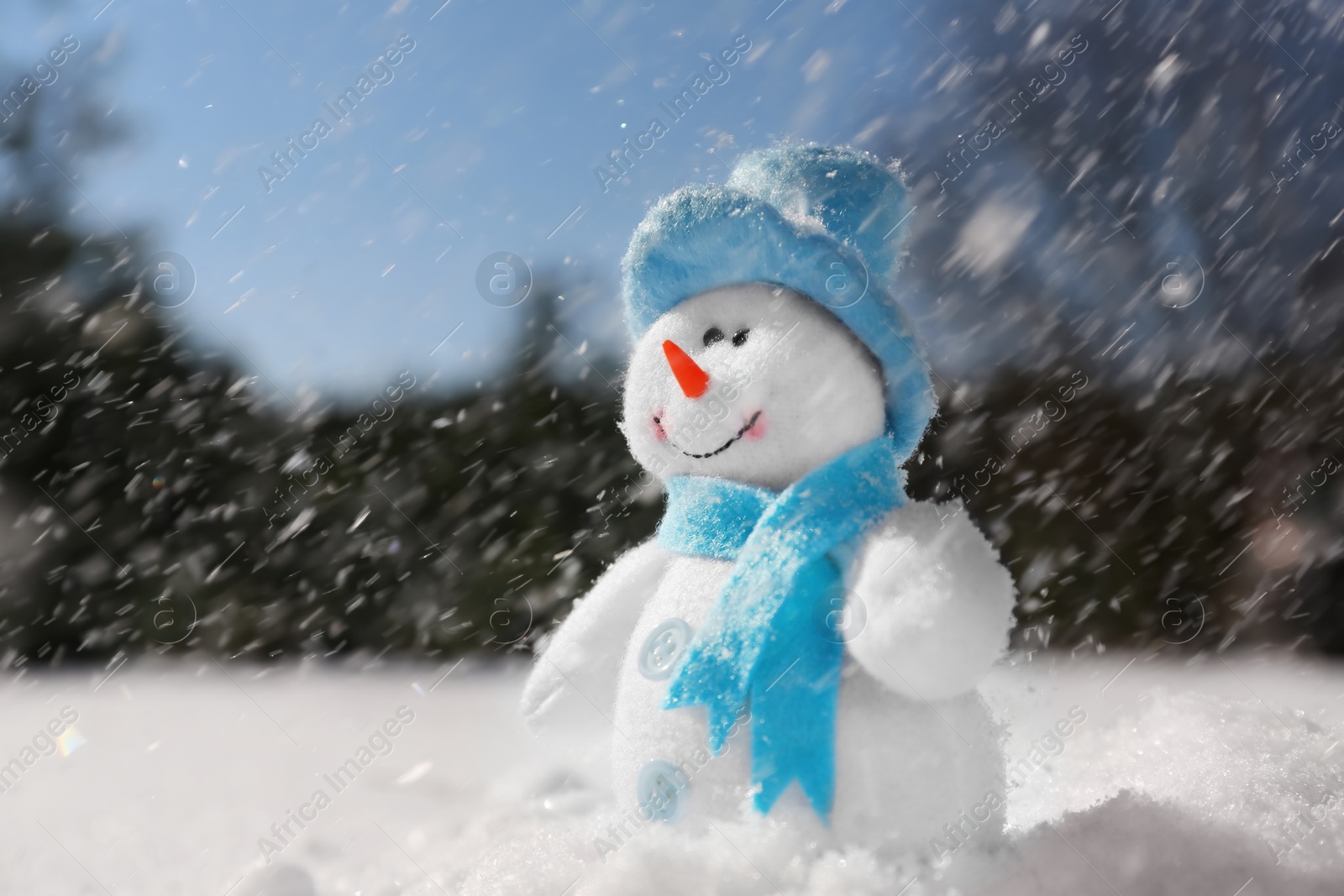 Photo of Cute small decorative snowman outdoors on winter day, space for text