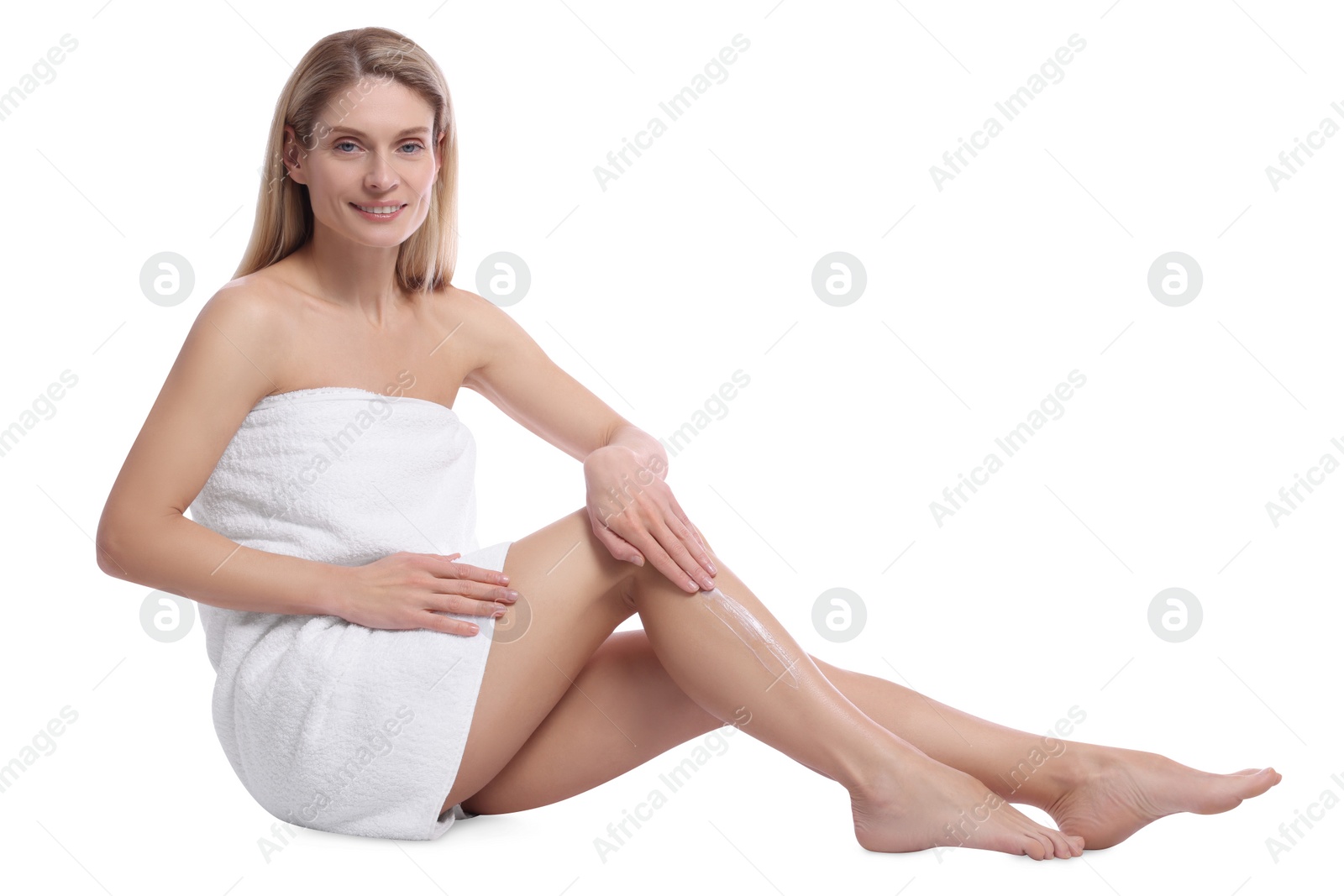 Photo of Woman applying body cream onto her leg against white background