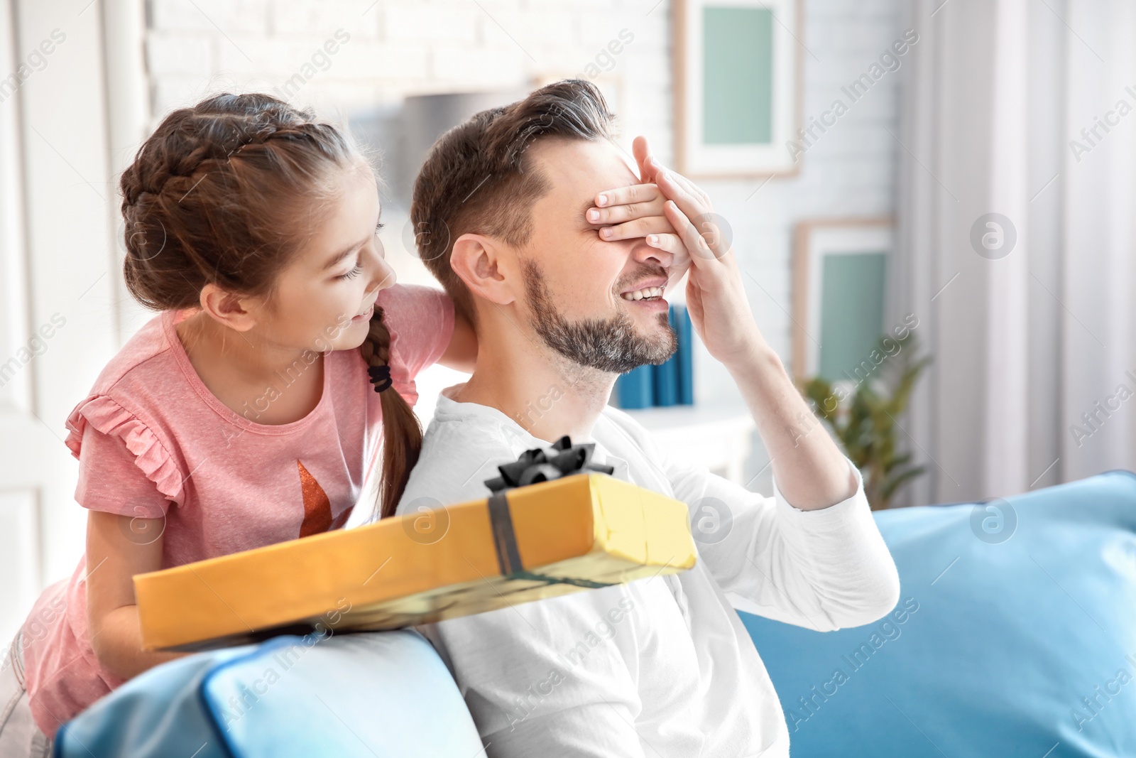 Photo of Man receiving gift for Father's Day from his daughter at home