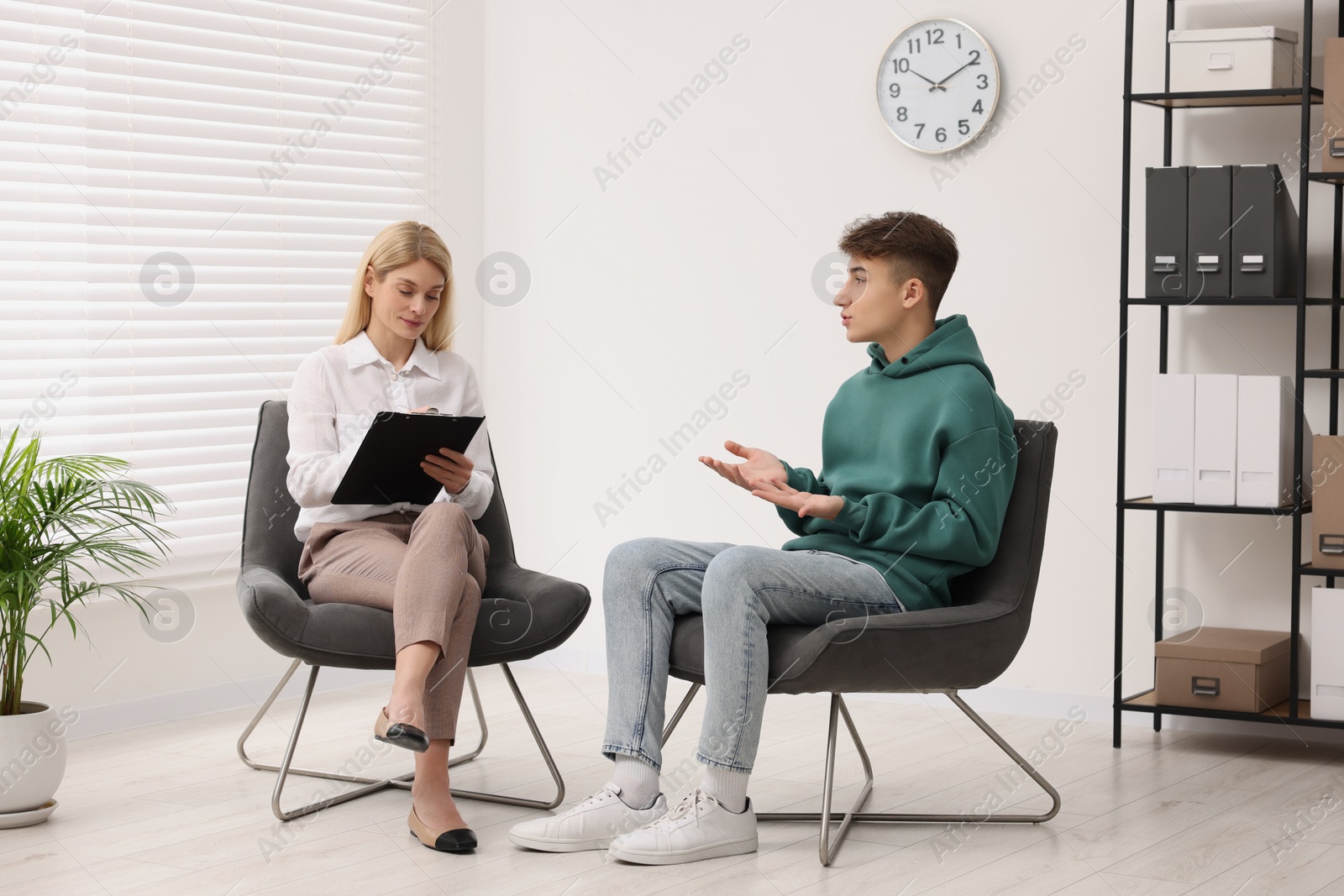 Photo of Psychologist working with teenage boy in office