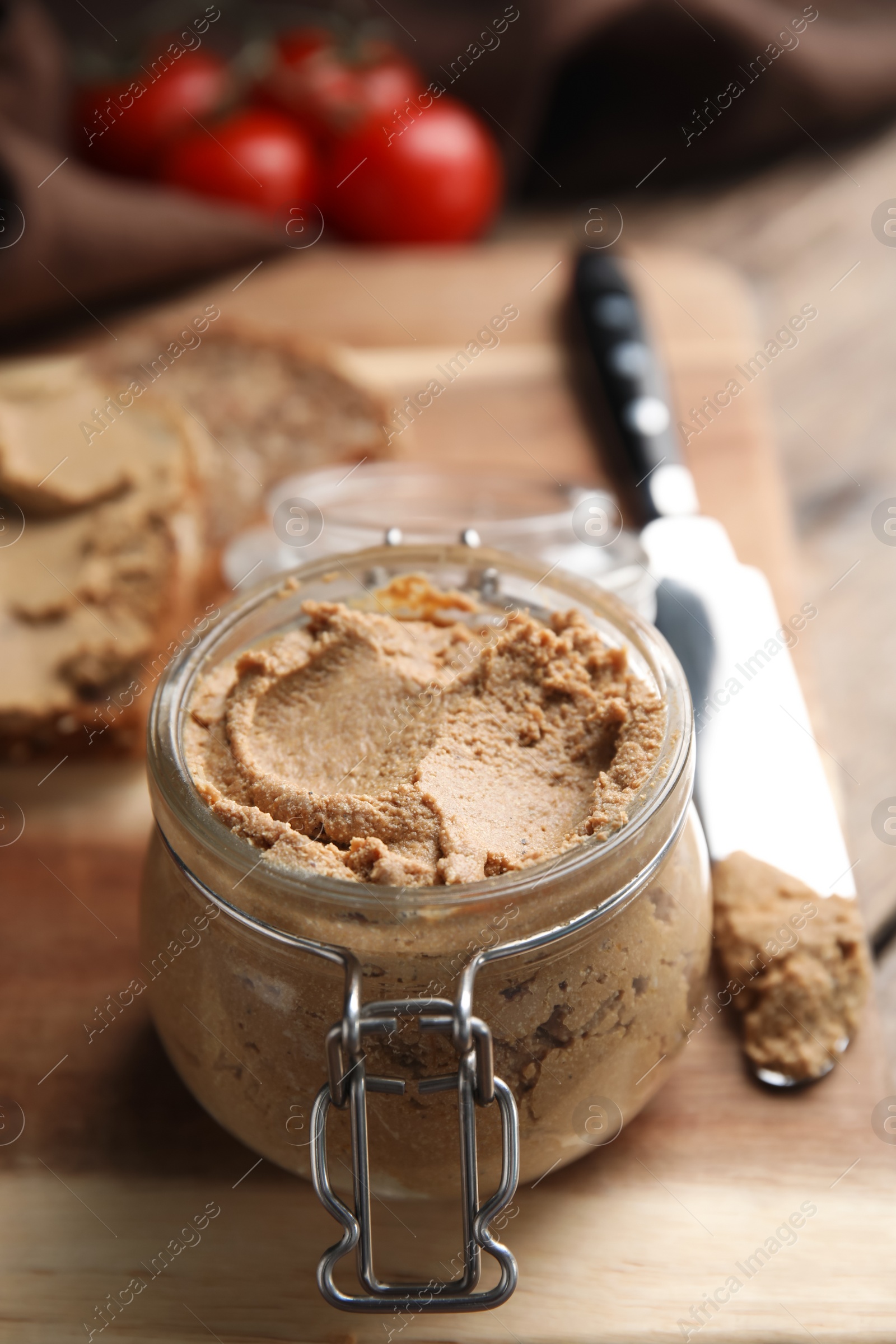 Photo of Delicious meat pate with knife on wooden table, closeup