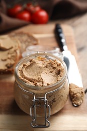 Delicious meat pate with knife on wooden table, closeup