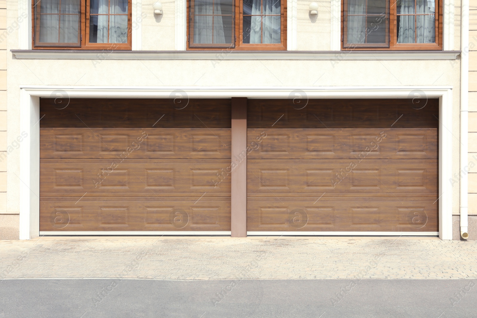 Photo of Building with double brown sectional garage door on sunny day