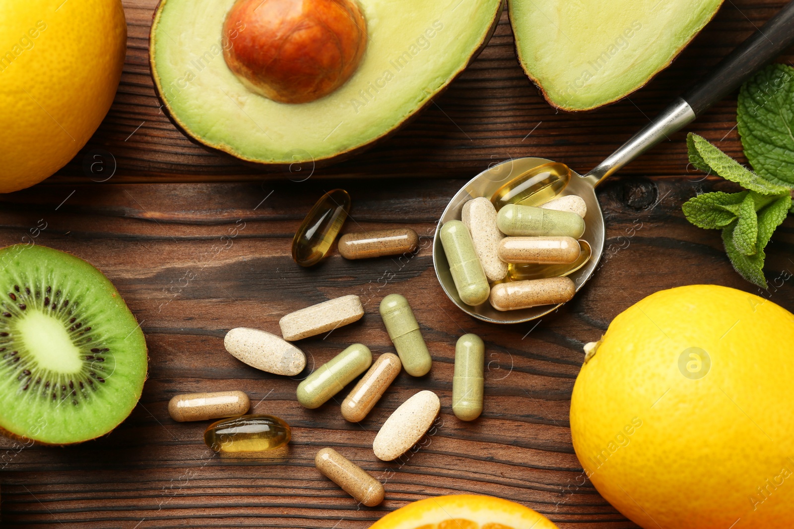 Photo of Different vitamin pills and fresh fruits on wooden table, flat lay