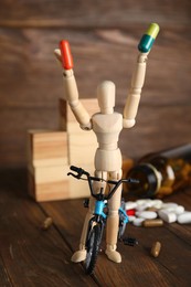 Photo of Pills, sportsman and bike model on wooden background. Using doping in cycling sport concept