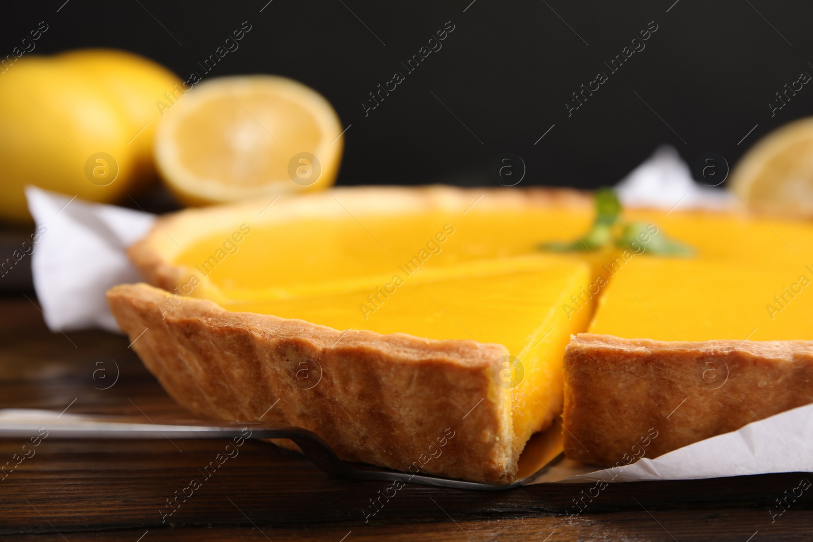 Photo of Delicious homemade lemon pie on wooden table, closeup