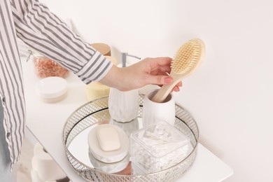 Photo of Bath accessories. Woman with brush indoors, closeup