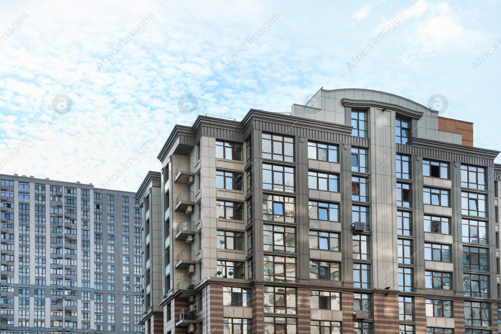 Photo of Modern buildings with tinted windows against sky. Urban architecture