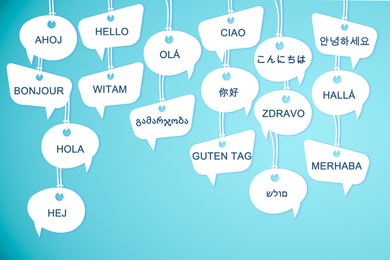 Speech bubbles with greeting words in different foreign languages on light blue background