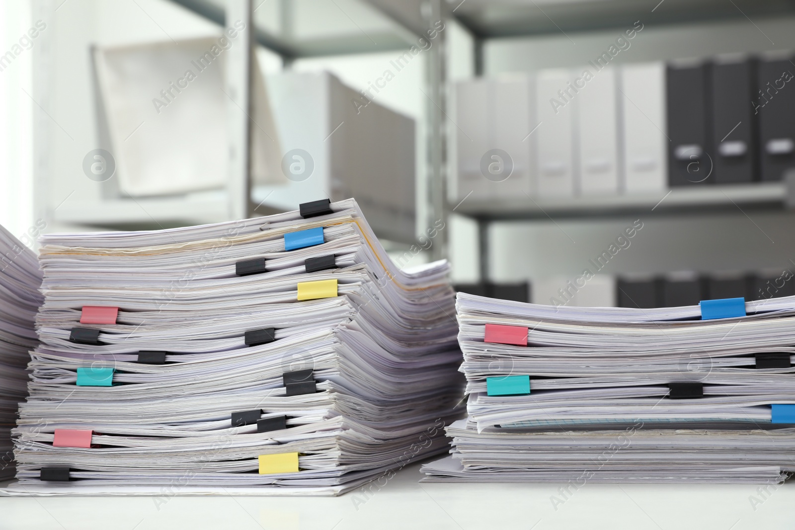 Photo of Stacks of documents with paper clips on office desk