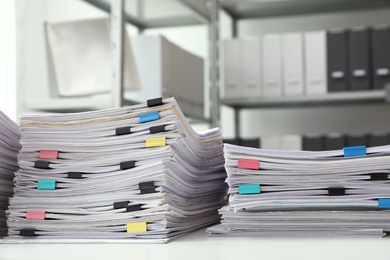 Stacks of documents with paper clips on office desk