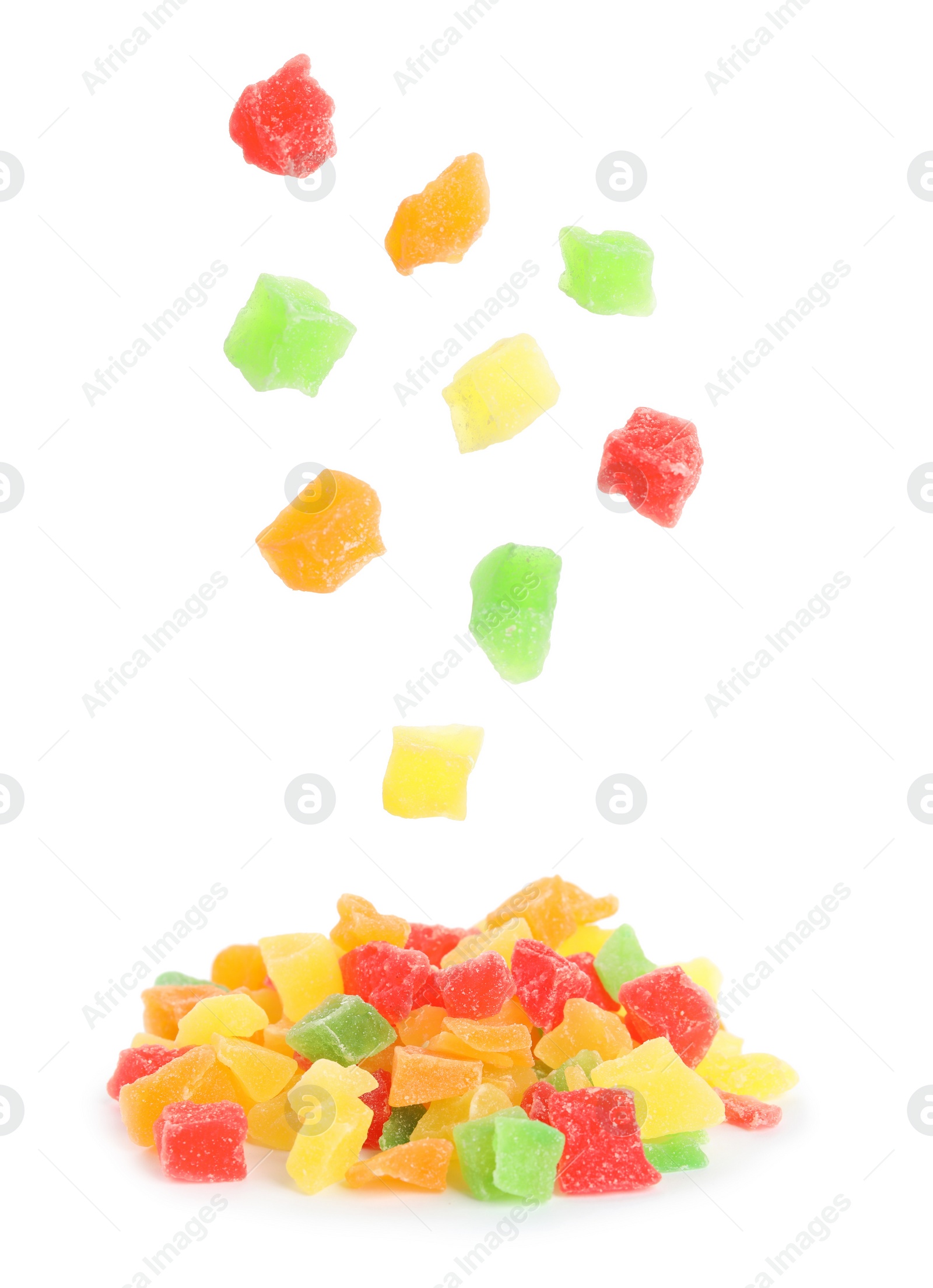 Image of Tasty pieces of candied fruits falling into pile on white background 