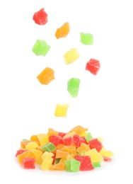 Image of Tasty pieces of candied fruits falling into pile on white background 