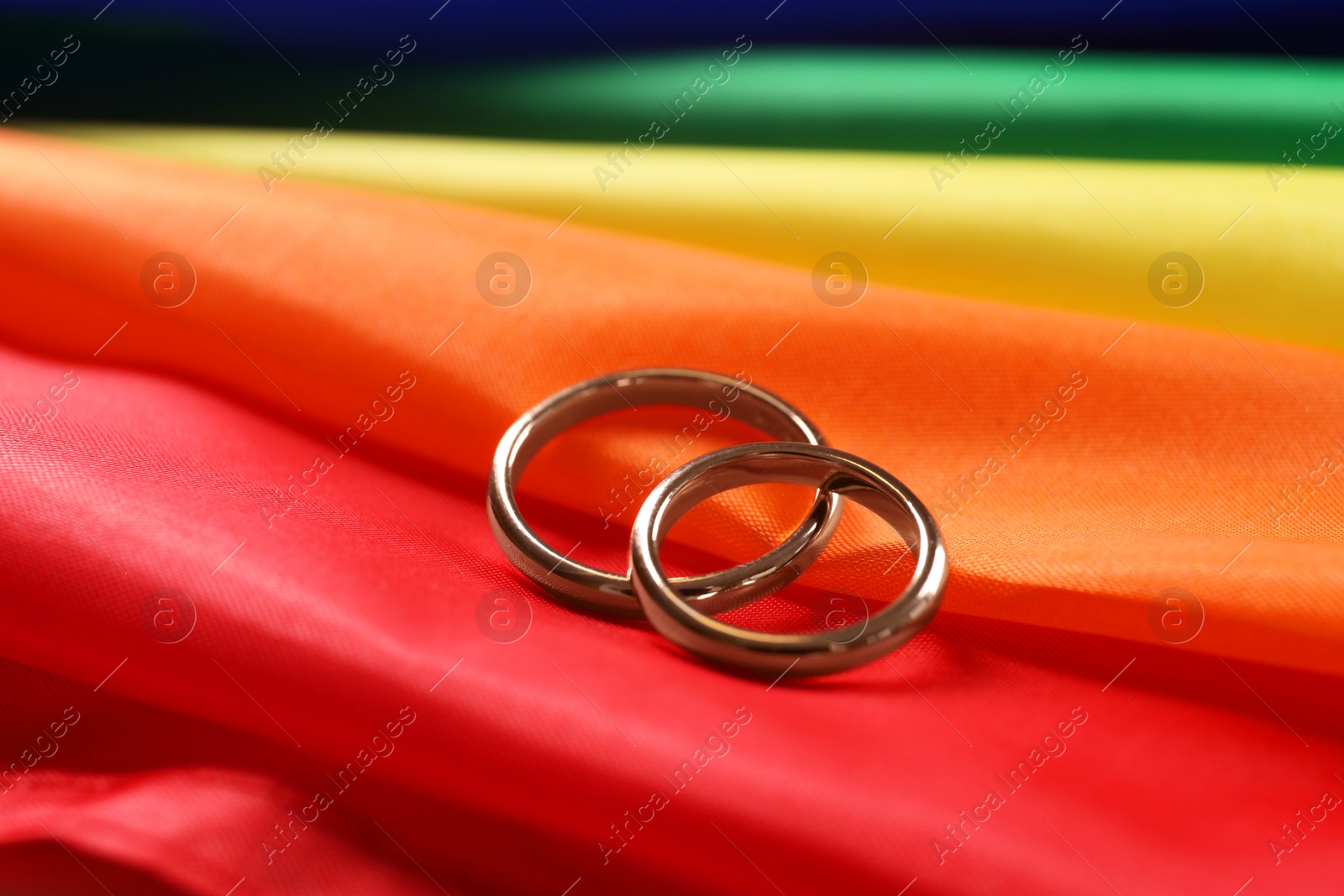 Photo of Wedding rings on rainbow LGBT flag, closeup