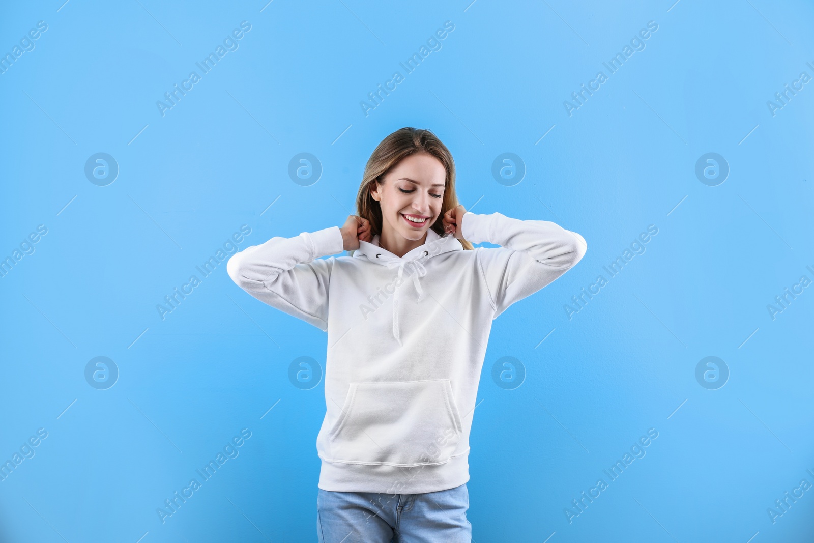 Photo of Portrait of woman in hoodie sweater on color background. Space for design