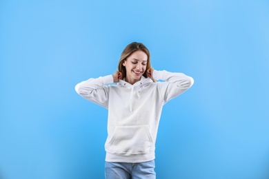 Photo of Portrait of woman in hoodie sweater on color background. Space for design