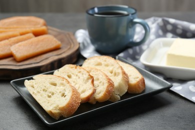 Photo of Delicious quince paste, bread and butter on grey textured table, closeup