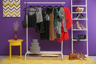 Rack with collection of beautiful festive clothes in stylish room interior