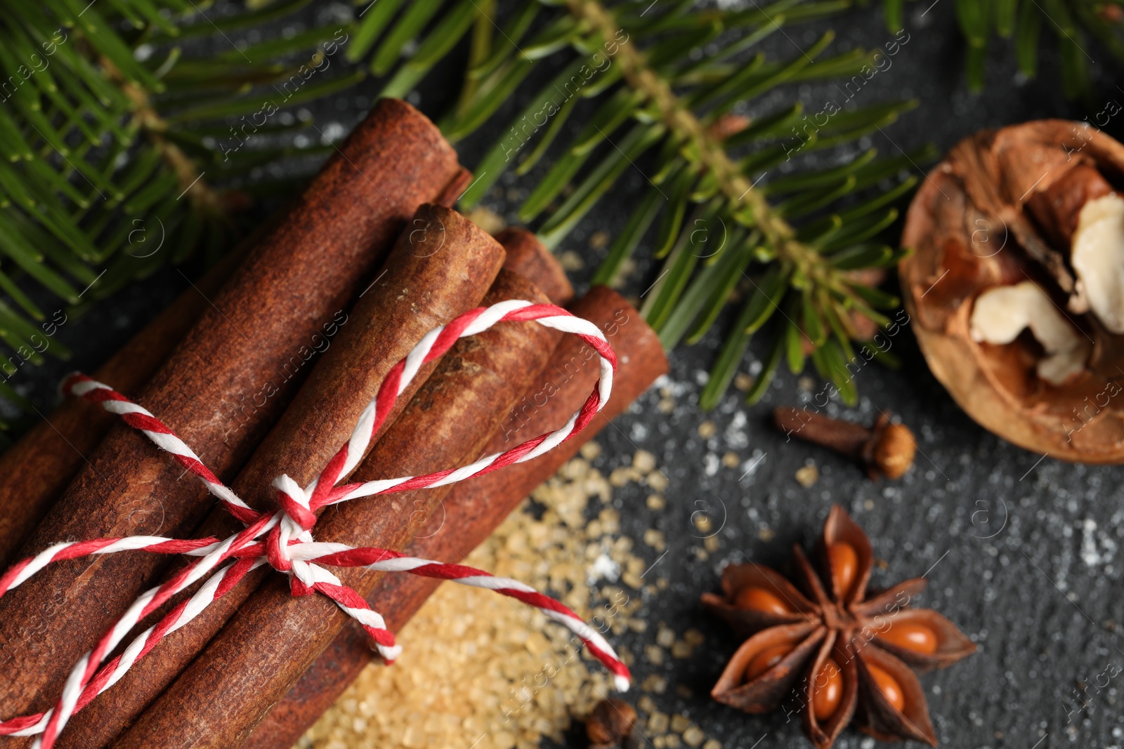 Photo of Different aromatic spices and fir branches on grey table, flat lay