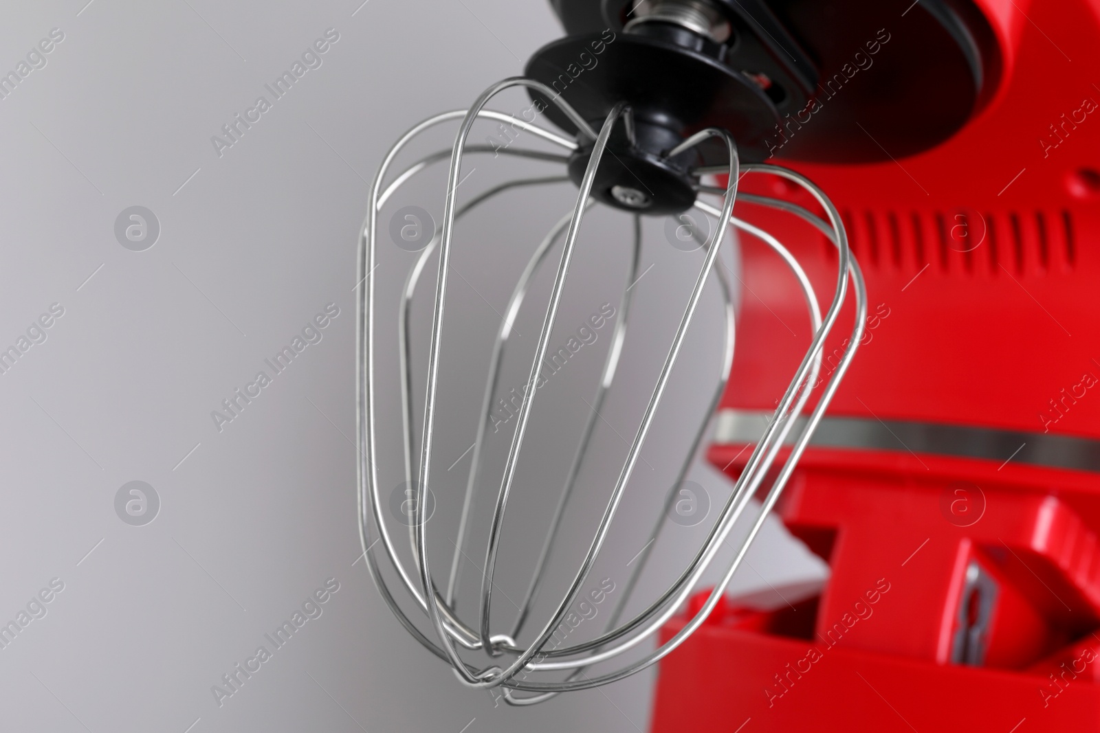 Photo of Modern red stand mixer on light gray background, closeup