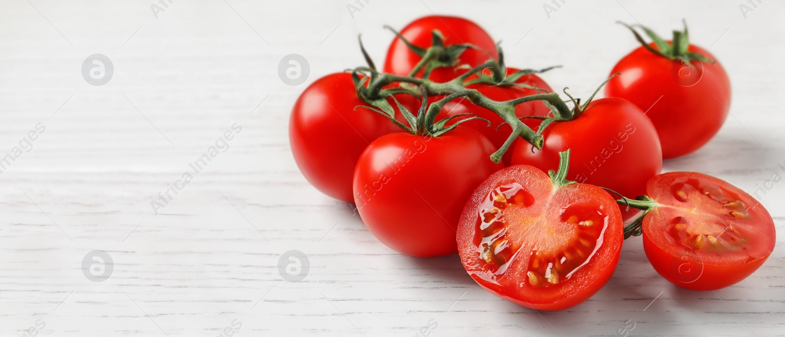 Image of Fresh cherry tomatoes on white wooden table, space for text. Banner design 