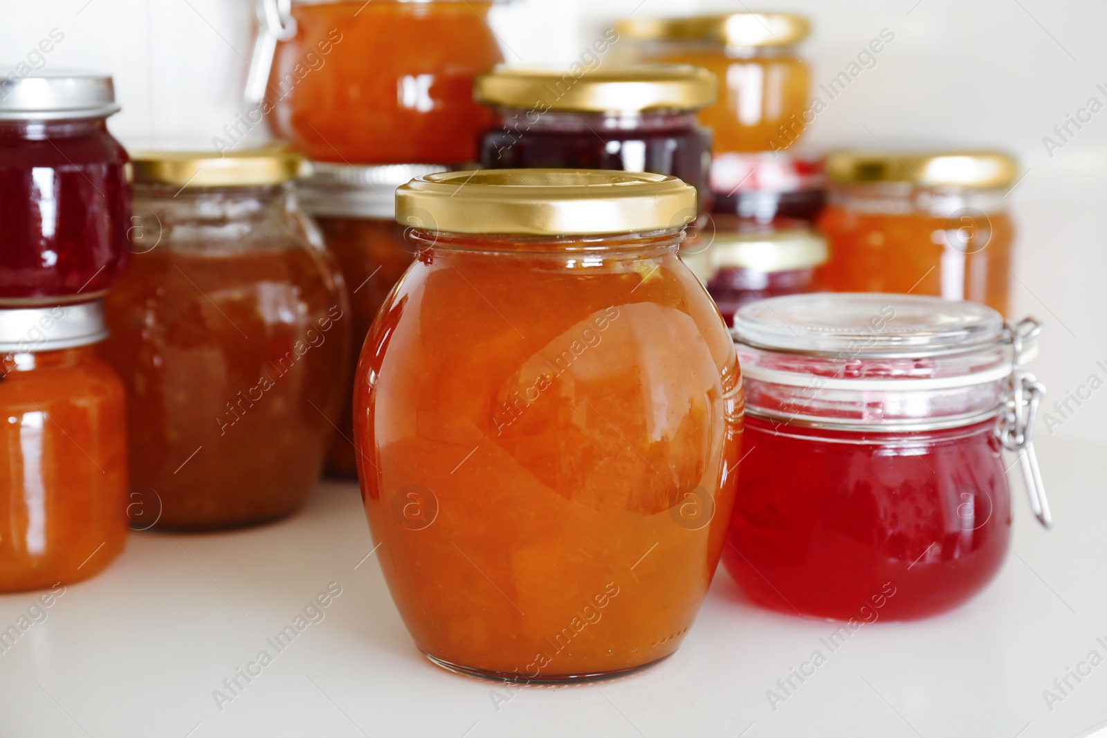 Photo of Jars with different sweet jam on table