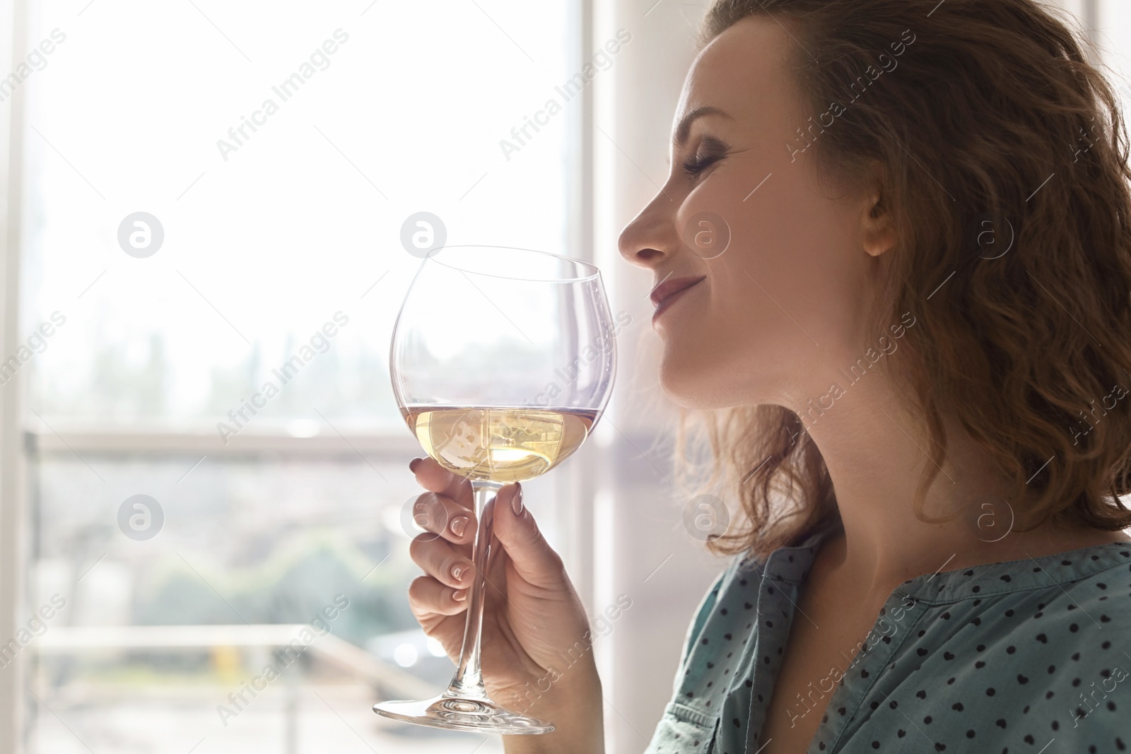 Photo of Woman with glass of delicious wine indoors