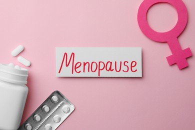 Card with word Menopause, pills and female gender sign on pink background, flat lay