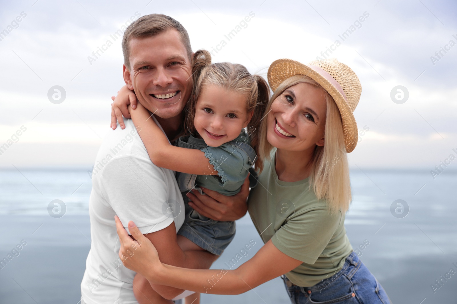 Photo of Happy family near sea on sunny summer day