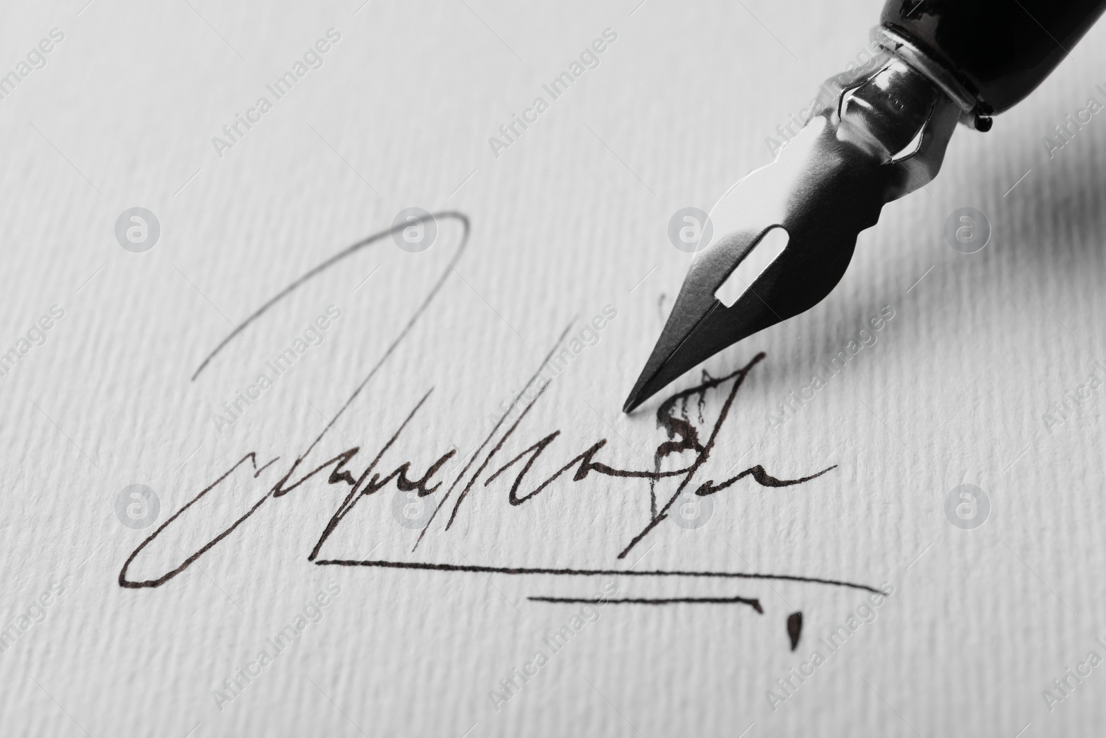 Photo of Signing on sheet of paper with fountain pen, closeup