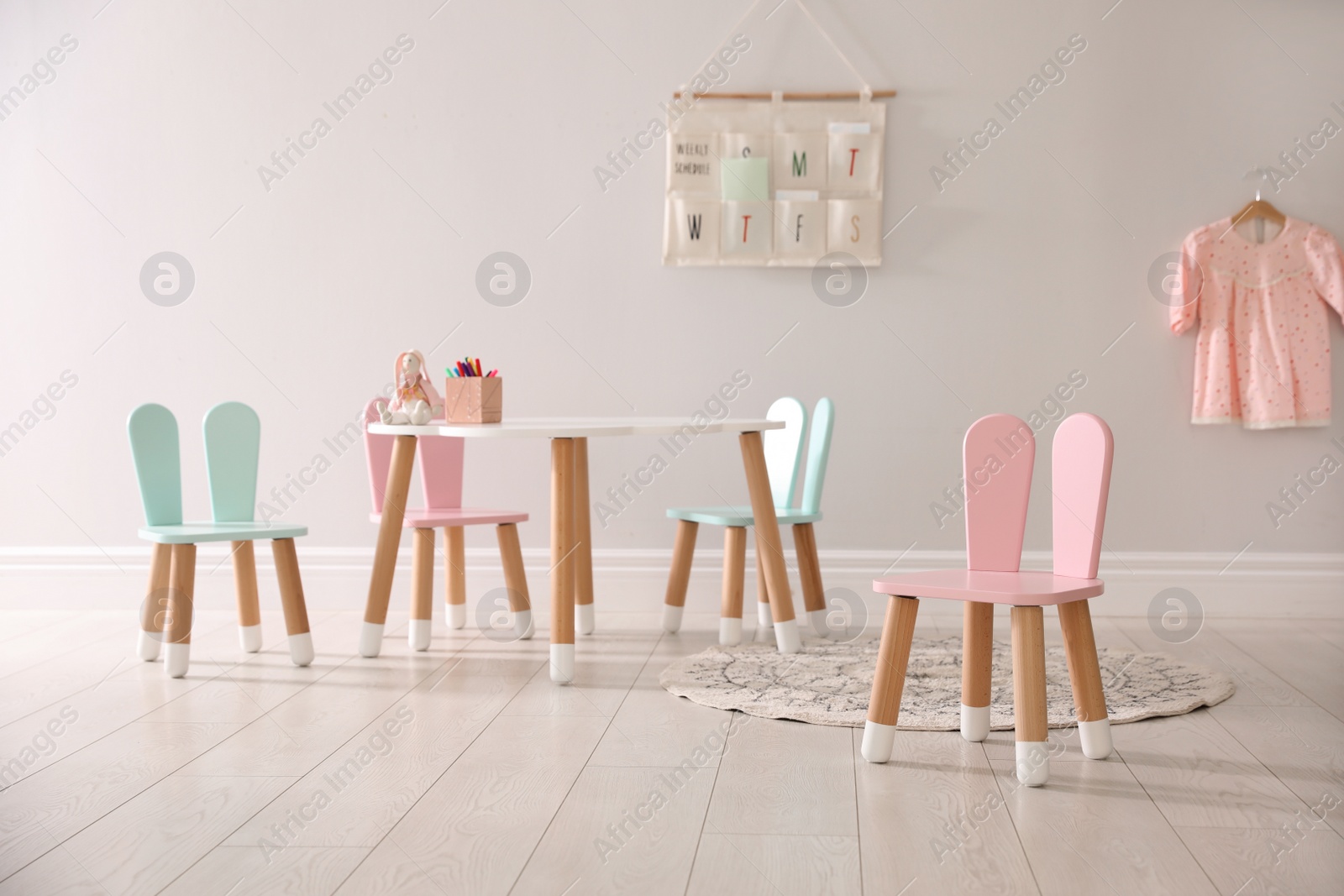 Photo of Small table and chairs with bunny ears indoors. Children's room interior