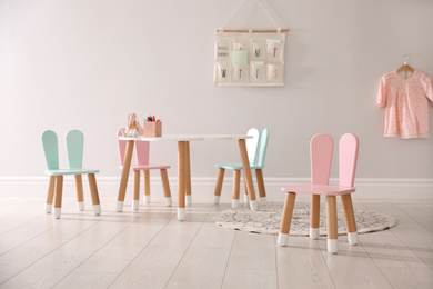 Small table and chairs with bunny ears indoors. Children's room interior