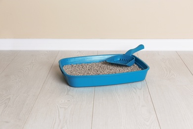 Photo of Cat toilet with scoop on floor. Pet care