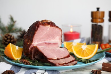 Photo of Plate with delicious ham, rosemary and orange on white wooden table. Christmas dinner