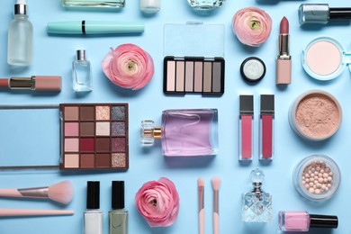 Photo of Flat lay composition with different makeup products and beautiful spring flowers on light blue background