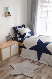 Bed with stylish linens in children's room