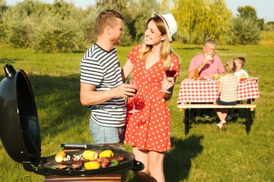 Happy family having barbecue in park on sunny day