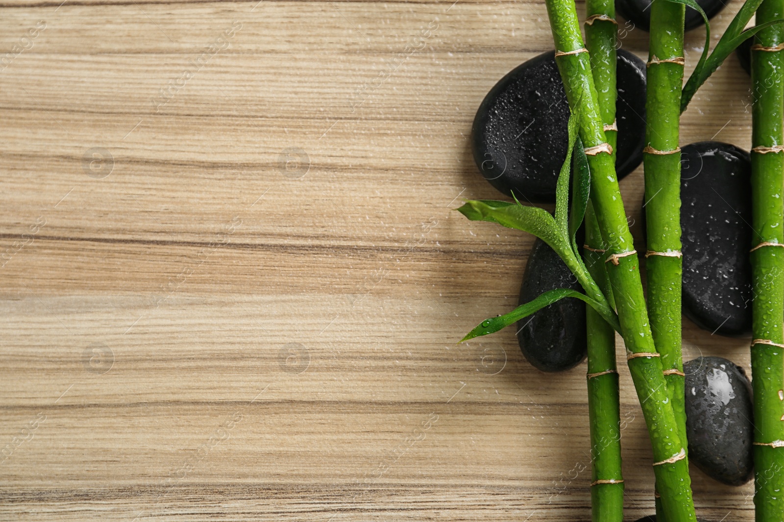 Photo of Flat lay composition with green bamboo stems on wooden background. Space for text