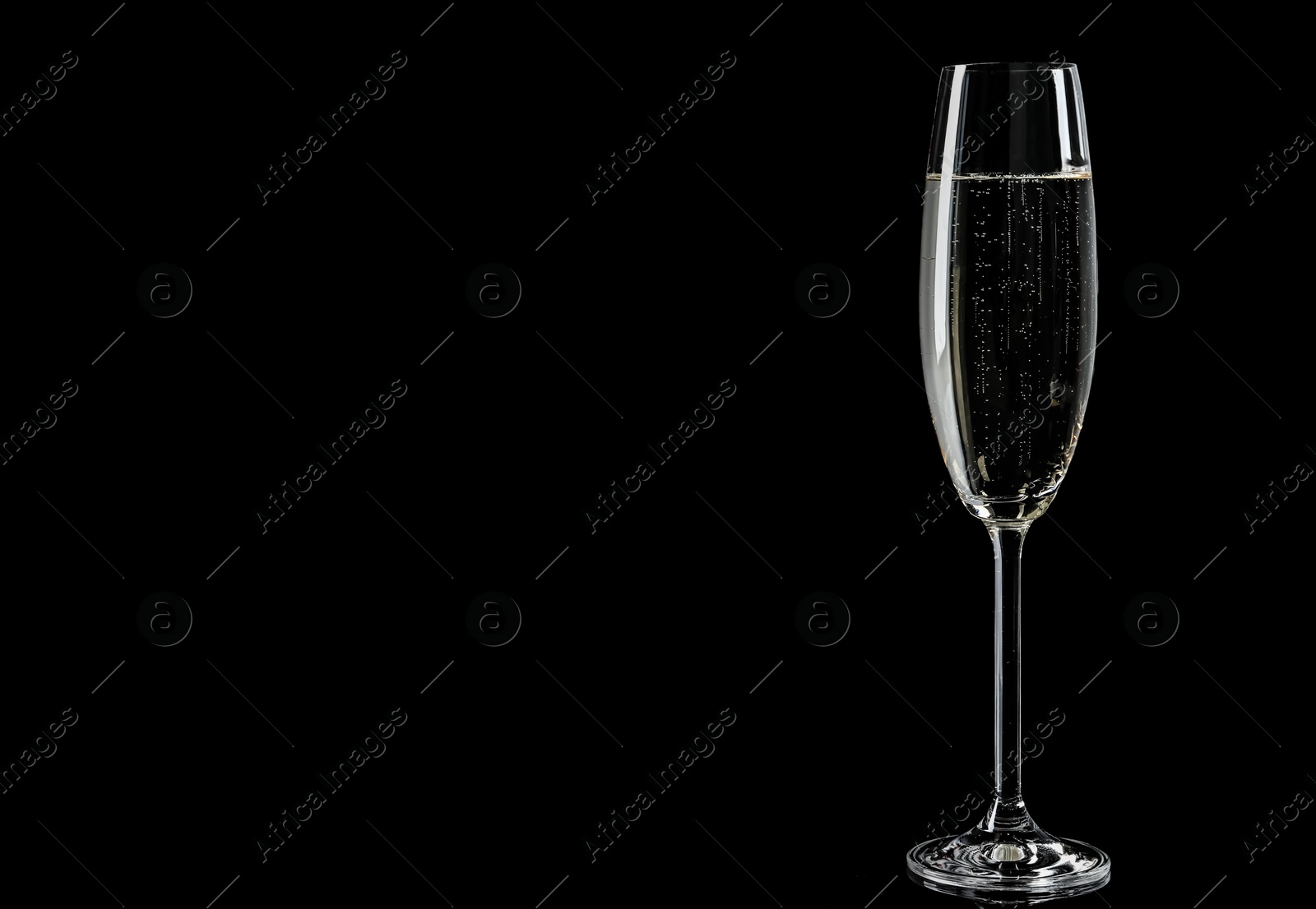 Photo of Glass of champagne on black background, space for text