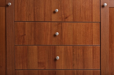 Photo of Wooden wardrobe drawers as background, closeup view