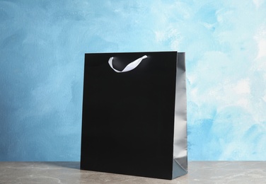 Photo of Paper shopping bag on table against color background. Mock up for design