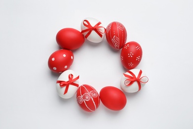 Frame made of red painted Easter eggs on white background, space for text