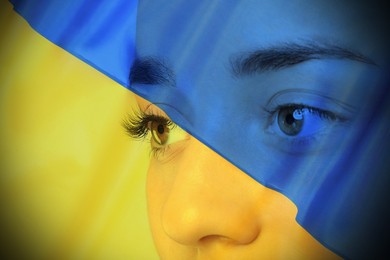 Image of Double exposure of Ukrainian national flag and young woman, closeup view