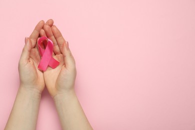 Breast cancer awareness. Woman with pink ribbon on color background, top view. Space for text