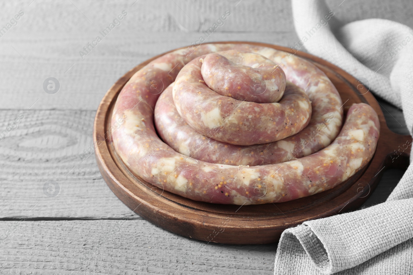 Photo of Homemade sausages on light grey wooden table, closeup